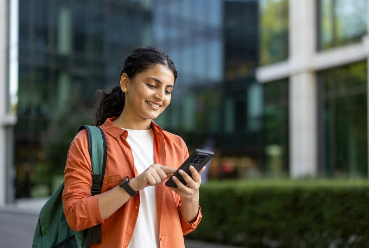 A student reviewing university admissions materials on a phone.