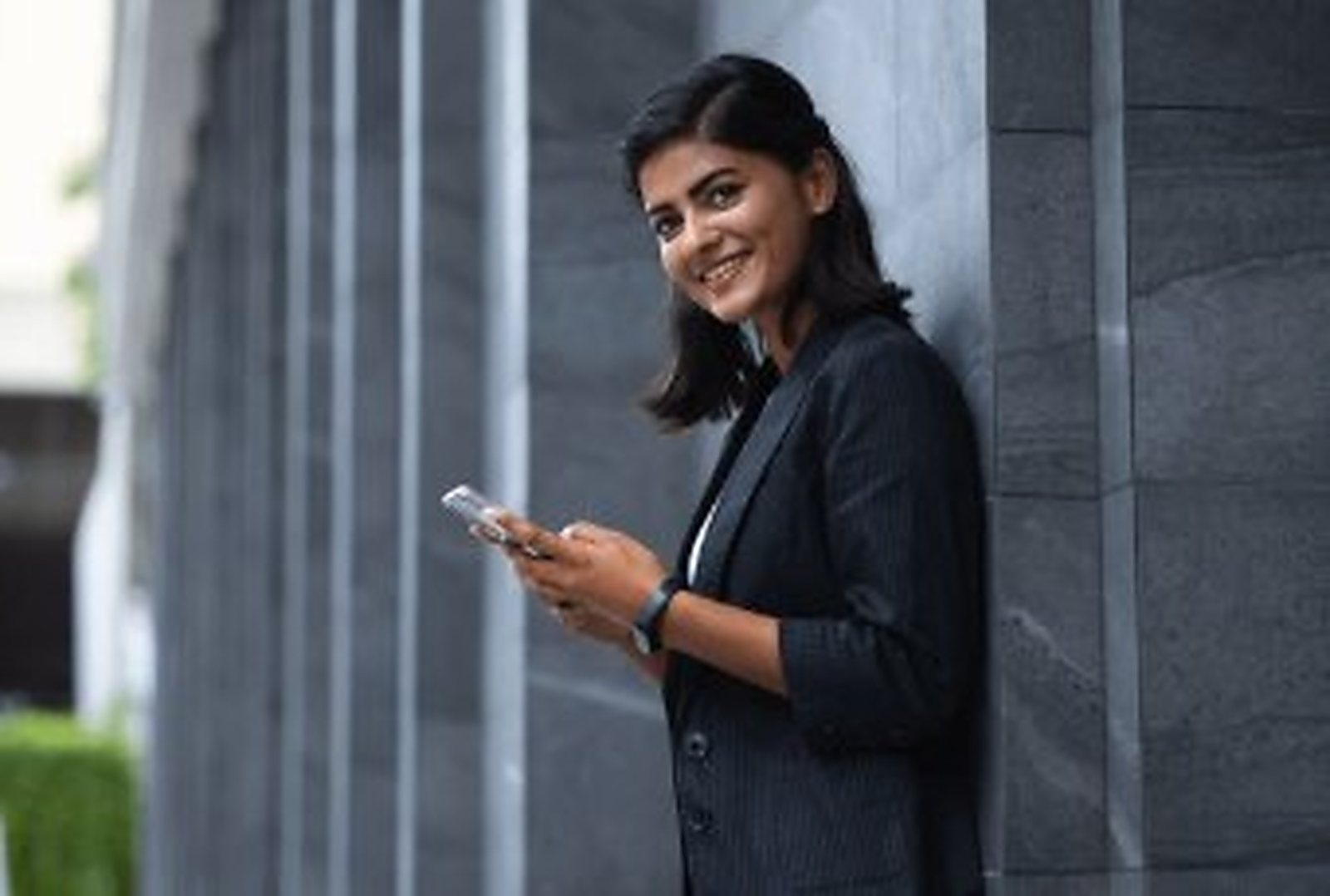 A graduate in a blazer outside a city office building.