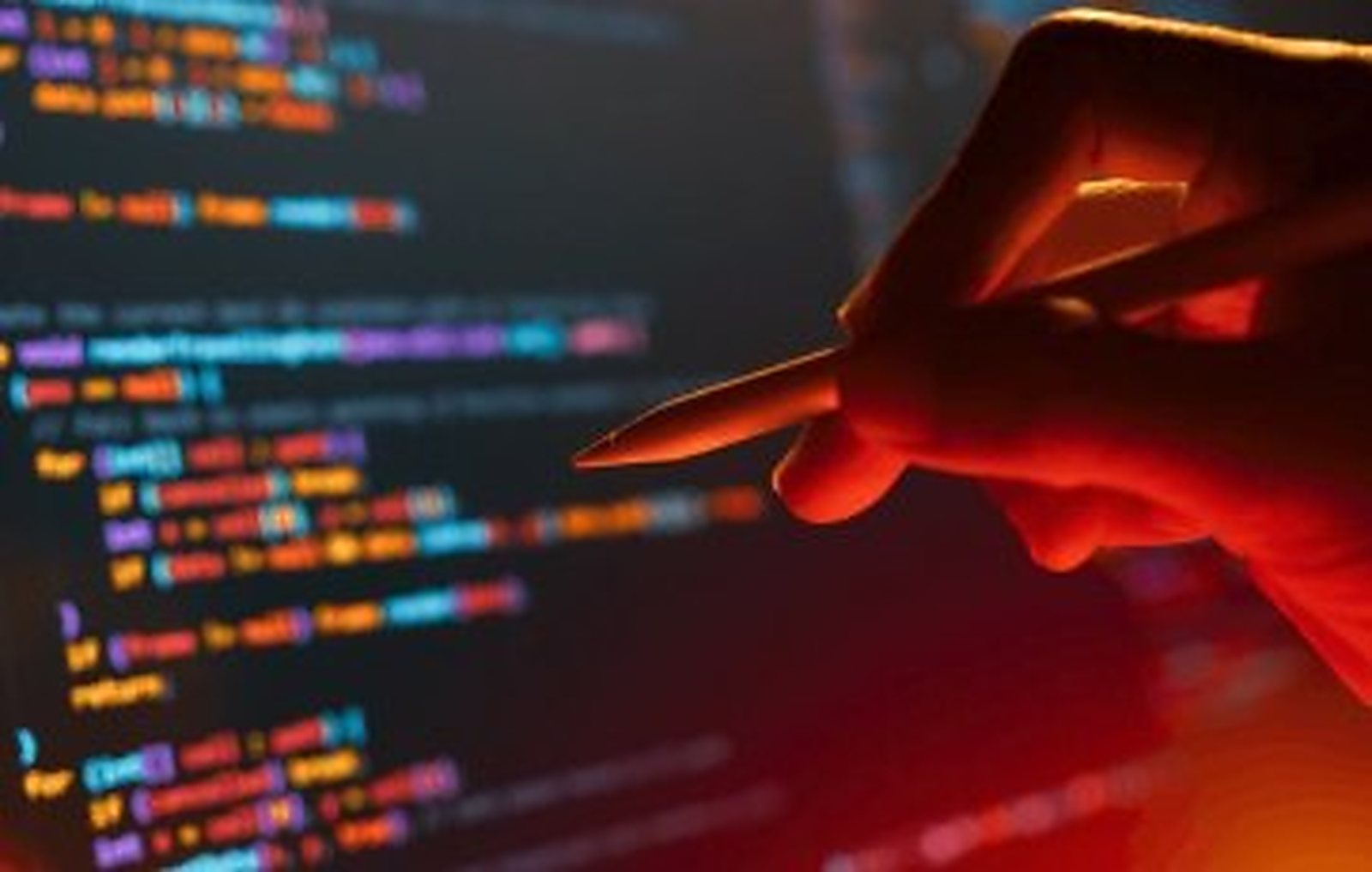 A hand holding a stylus above a screen of colour-highlighted code.
