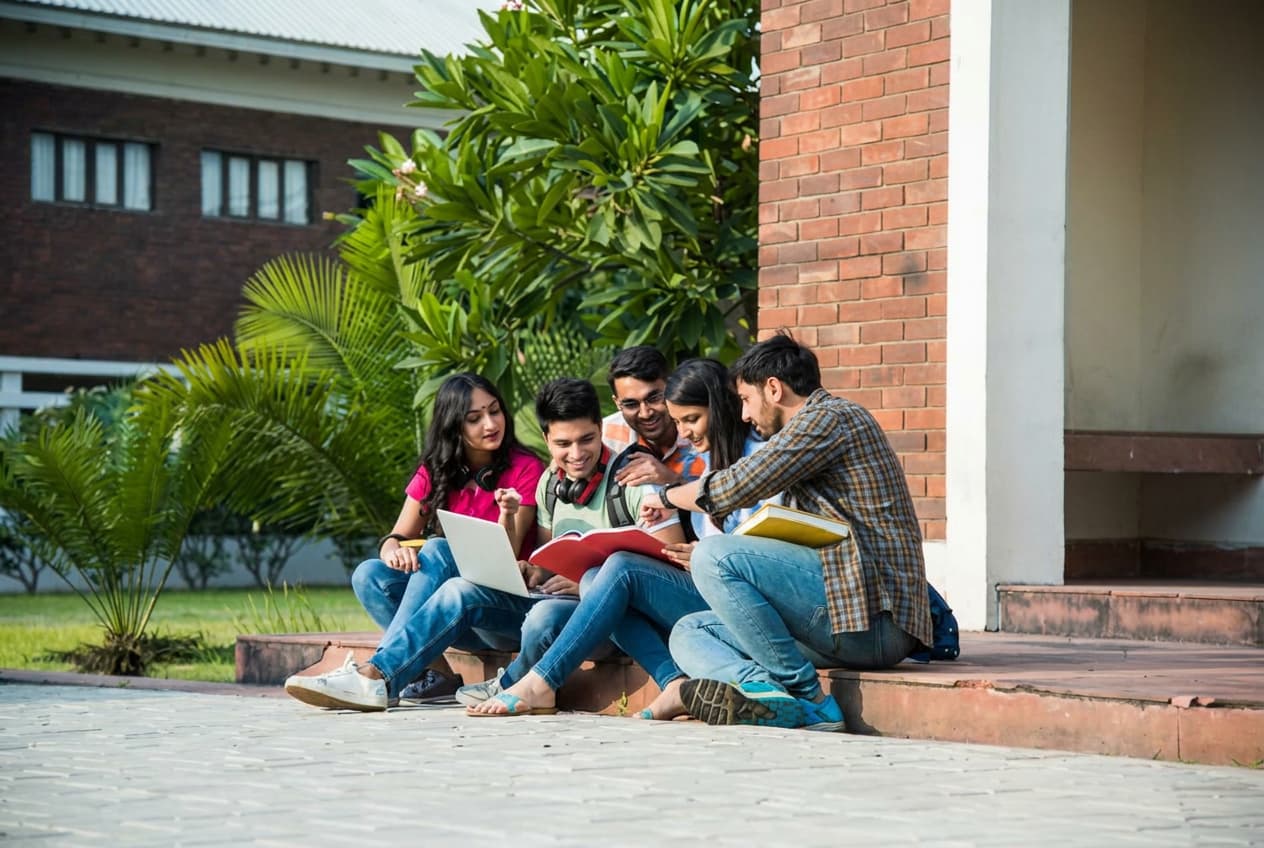 A student reading study notes by a campus bookshelf.