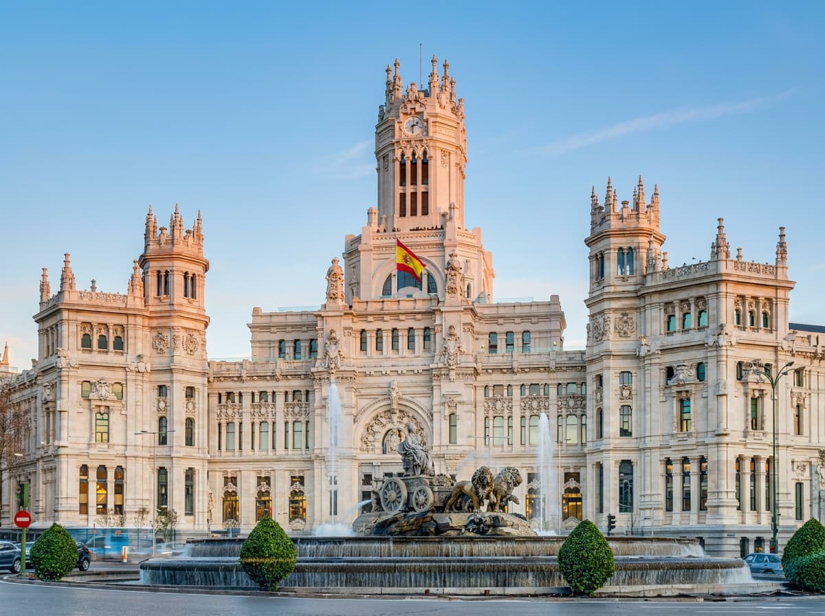 The Cibeles fountain and palace in Madrid in soft early morning light.