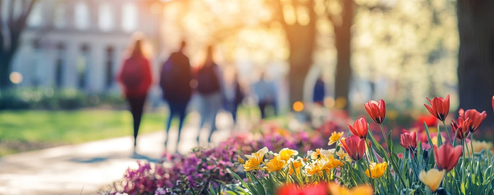 Students walking through a campus garden in spring.