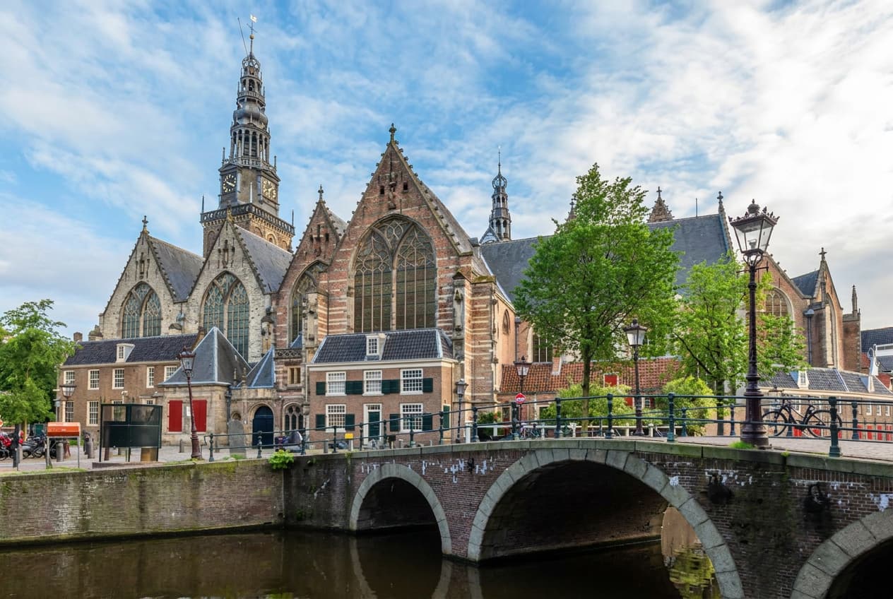 An Amsterdam canal bridge in front of the gothic Oude Kerk.