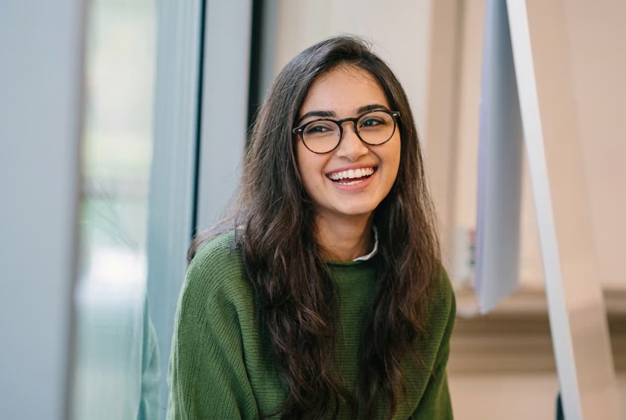 A student smiling by a window.